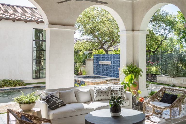 Image of a patio with a couch, pool and many objects outside for relaxing.